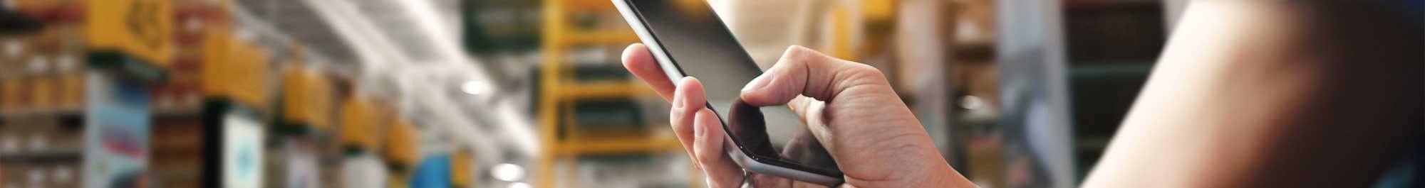 person using a smartphone while working in a warehouse