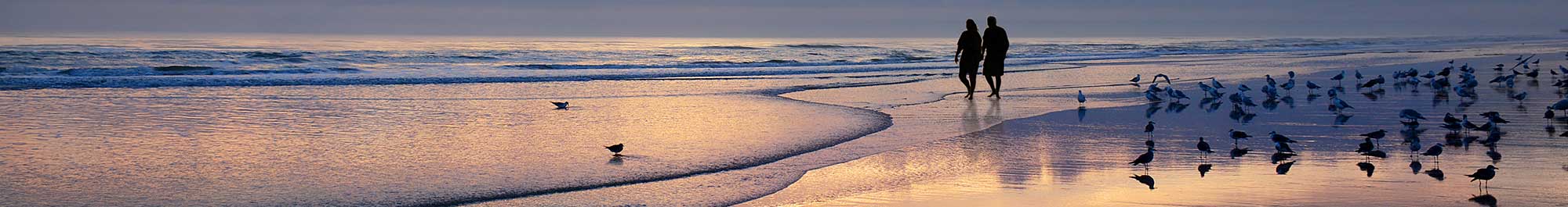 couple walking on a beach at sunset